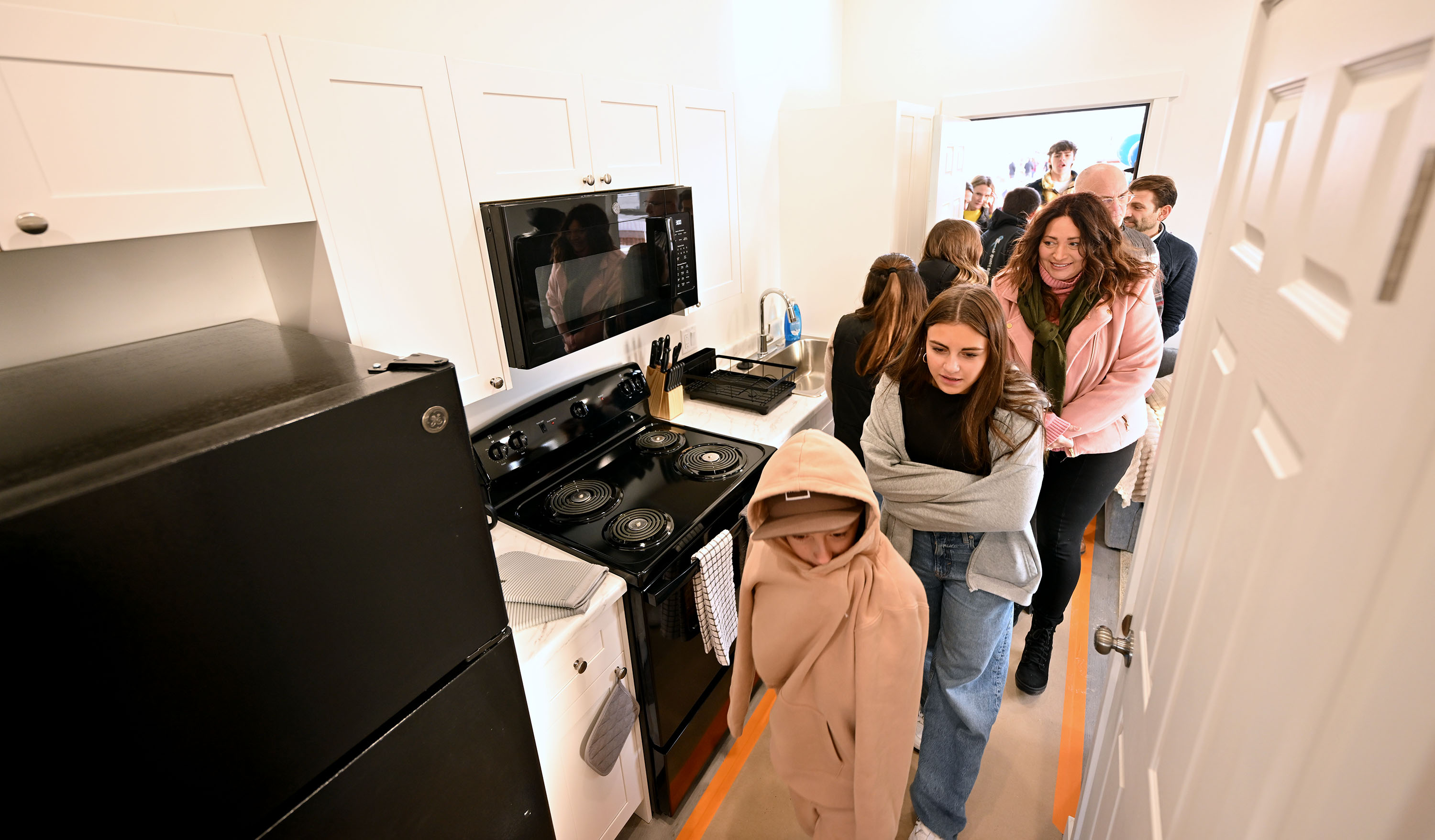 Visitors tour one of the newly completed homes as The Other Side Academy celebrates the grand opening of The Other Side Village on Monday.