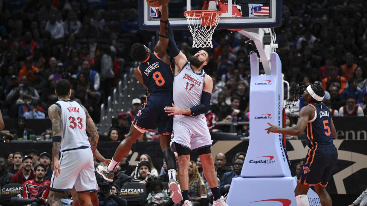 New York Knicks forward OG Anunoby (8) has his shot blocked by Washington Wizards center Jonas Valanciunas (17) during the first half of an NBA basketball game, Monday, Dec. 30, 2024, in Washington.