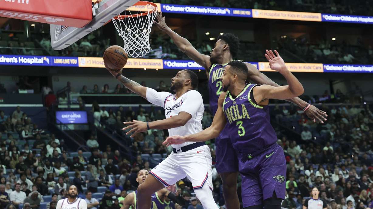 Los Angeles Clippers guard Norman Powell attempts a layup against New Orleans Pelicans forward Herbert Jones and guard CJ McCollum in the first half of an NBA basketball game in New Orleans, Monday, Dec. 30, 2024.