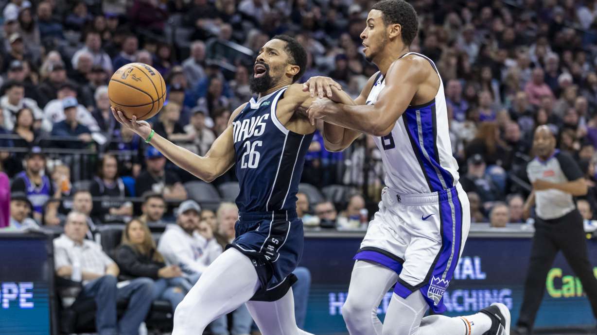 Dallas Mavericks guard Spencer Dinwiddie (26) drives to the basket past Sacramento Kings forward Keegan Murray, right, during the first half of an NBA basketball game, Monday, Dec. 30, 2024, in Sacramento, Calif.
