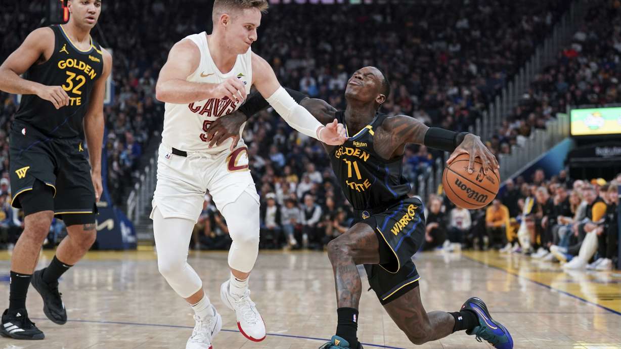 Golden State Warriors guard Dennis Schroder, right, moves the ball while defended by Cleveland Cavaliers guard Sam Merrill (5) during the first half an NBA basketball game Monday, Dec. 30, 2024, in San Francisco.