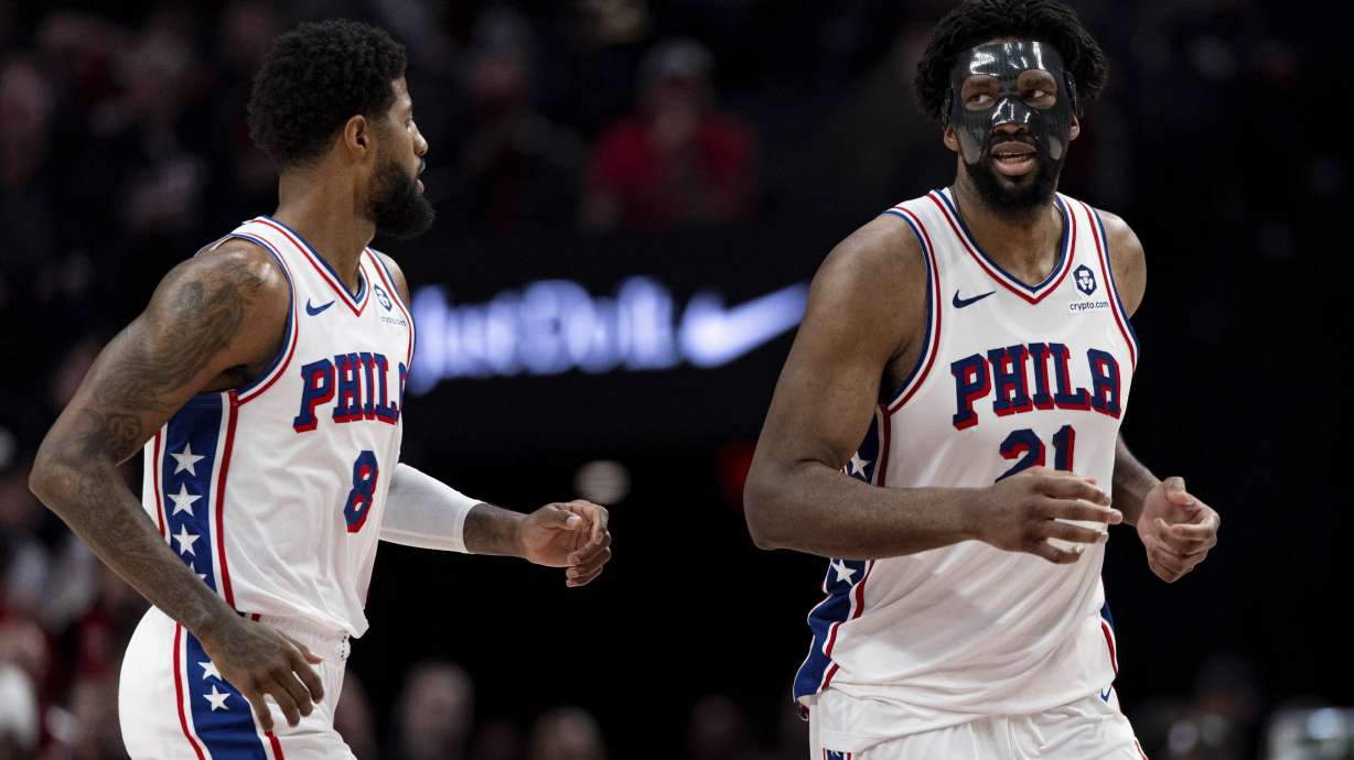 Philadelphia 76ers forward Paul George, left, and center Joel Embiid runs back against the Portland Trail Blazers during the second half of an NBA basketball game, Monday, Dec. 30, 2024, in Portland, Ore.