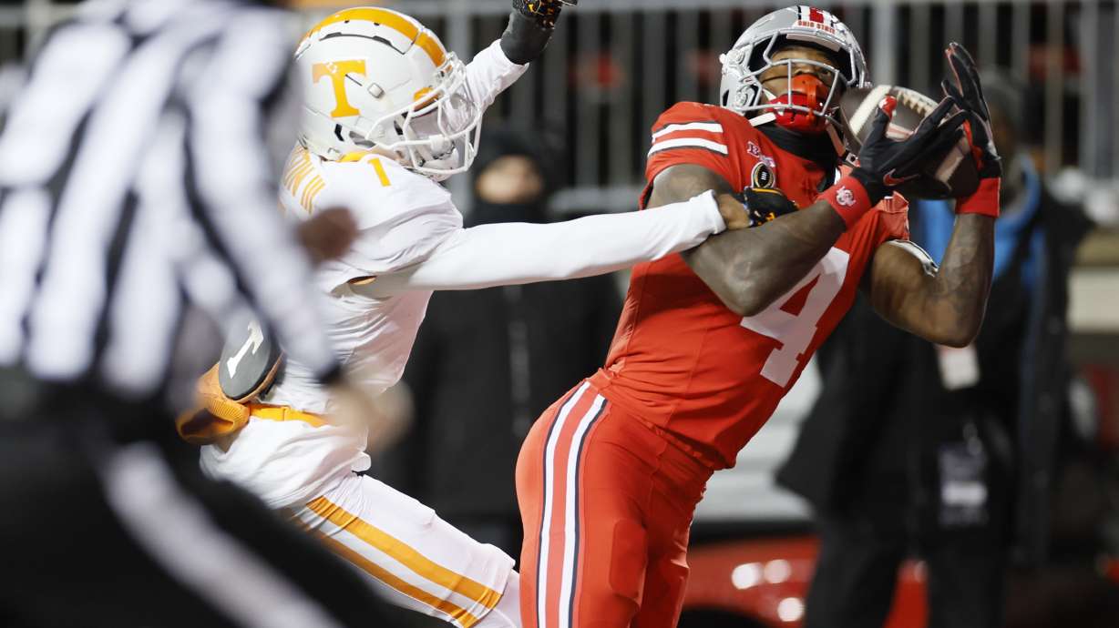 Ohio State receiver Jeremiah Smith, right, catches a touchdown pass against Tennessee defensive back Rickey Gibson, second from right, during the first half in the first round of the College Football Playoff, Saturday, Dec. 21, 2024, in Columbus, Ohio.