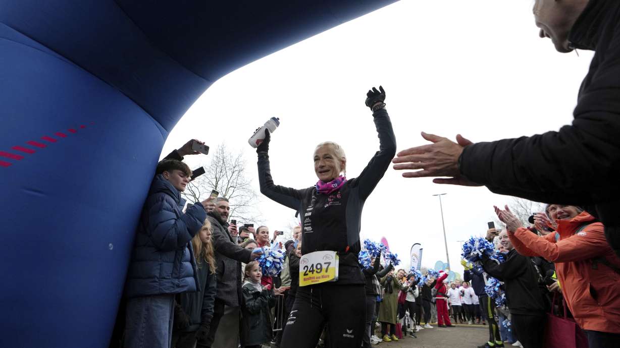 Belgian ultra runner Hilde Dosogne, center, is cheered on as she crosses the finish line during her 366th consecutive marathon in Ghent, Belgium, Tuesday.