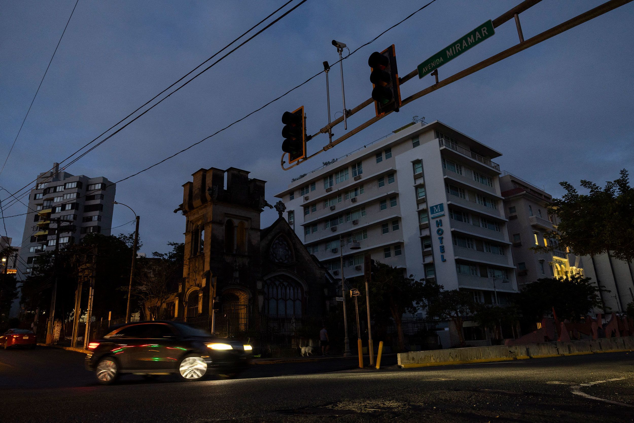 A car navigates an intersection without working stop lights in San Juan, Puerto Rico, after a major power outage hit the island on Tuesday.