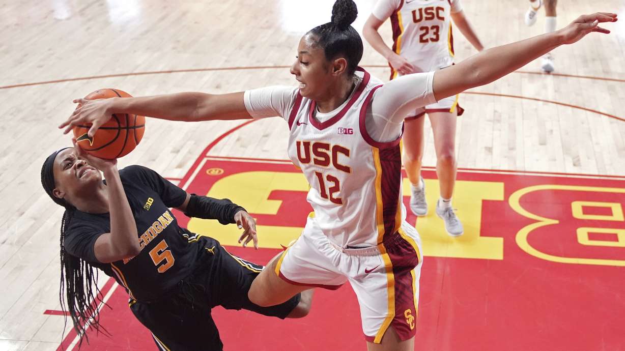 Michigan guard Brooke Daniels, left, has her shot blocked by Southern California guard JuJu Watkins during the second half of an NCAA college basketball game, Sunday, Dec. 29, 2024, in Los Angeles.