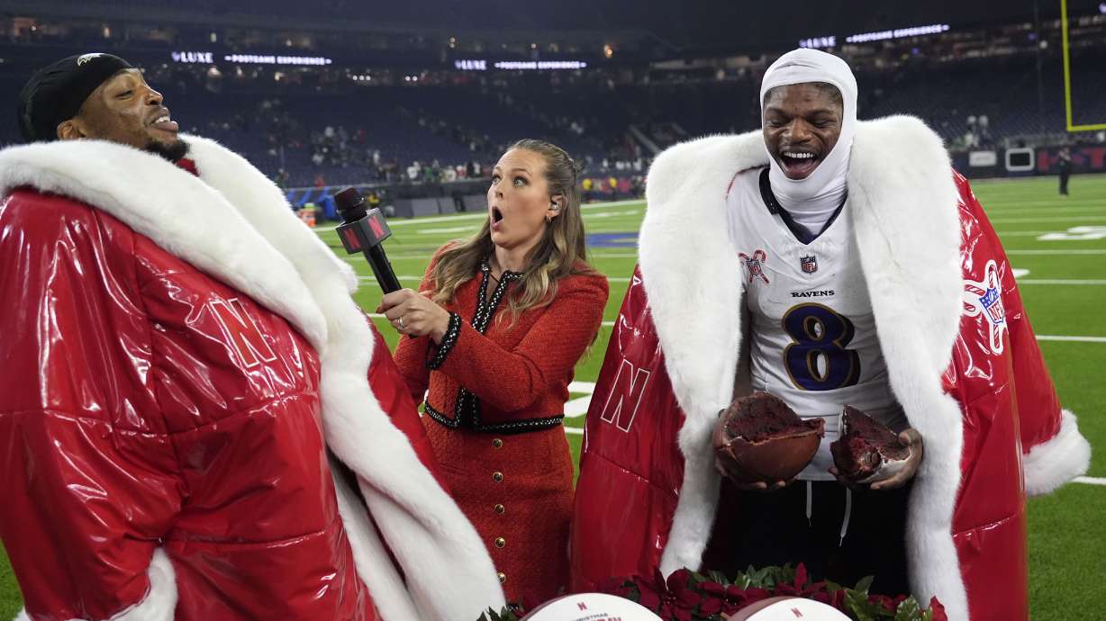 Baltimore Ravens running back Derrick Henry, left, and quarterback Lamar Jackson (8) are interviewed by Netflix reporter Jamie Erdahl after an NFL football game against the Houston Texans, Wednesday, Dec. 25, 2024, in Houston.