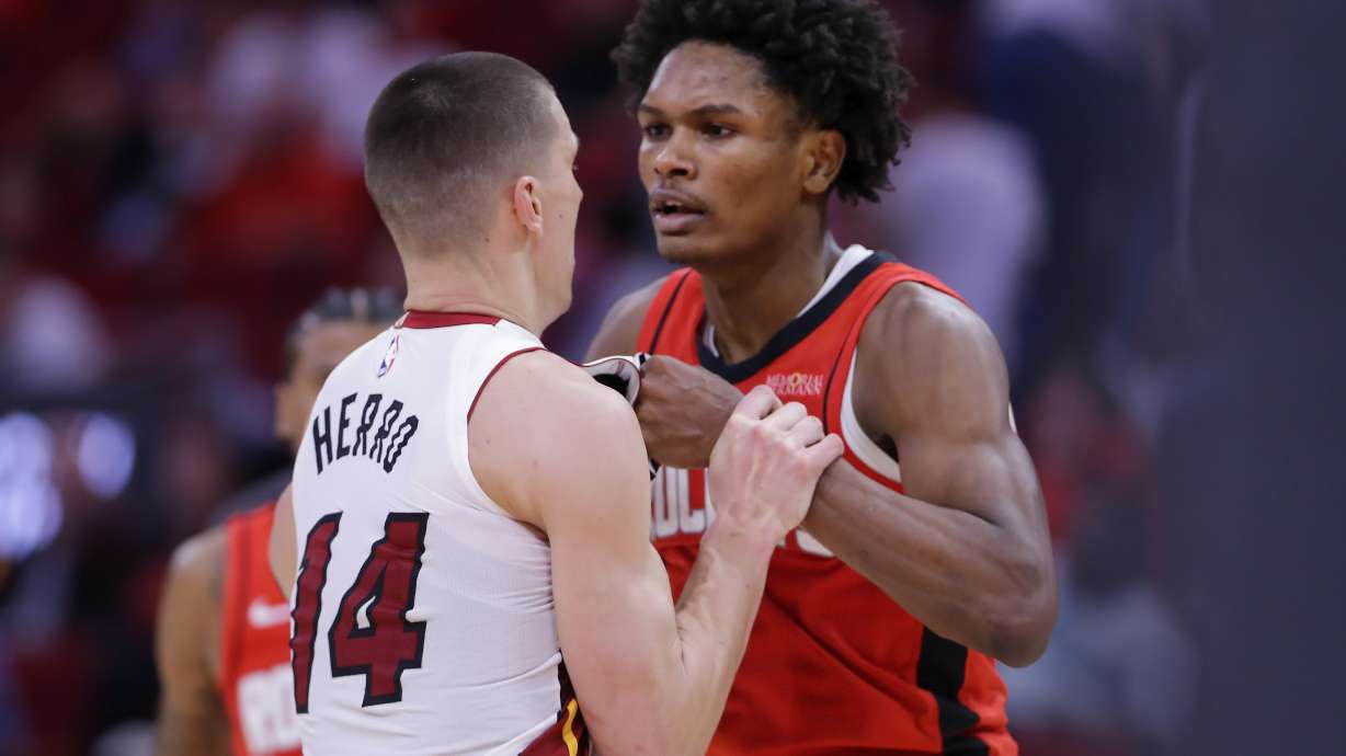 Houston Rockets forward Amen Thompson, right, and Miami Heat guard Tyler Herro (14) tug on each other before Thompson throws Herro to the court sparking a bench clearing brawl resulting in multiple ejections for both teams during the second half of an NBA basketball game Sunday, Dec. 29, 2024, in Houston.