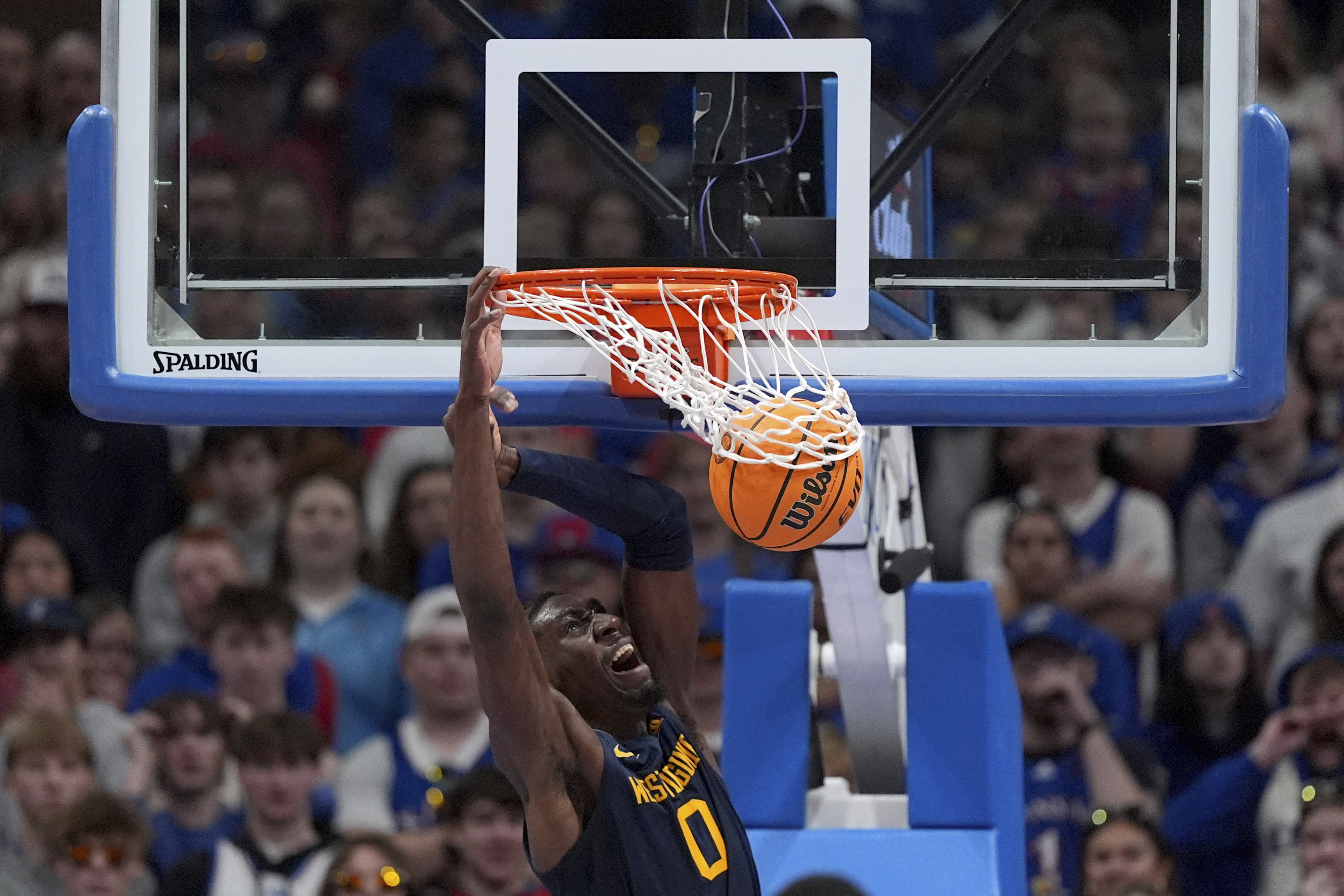 West Virginia center Eduardo Andre dunks the ball during the first half of an NCAA college basketball game against Kansas, Tuesday, Dec. 31, 2024, in Lawrence, Kan.