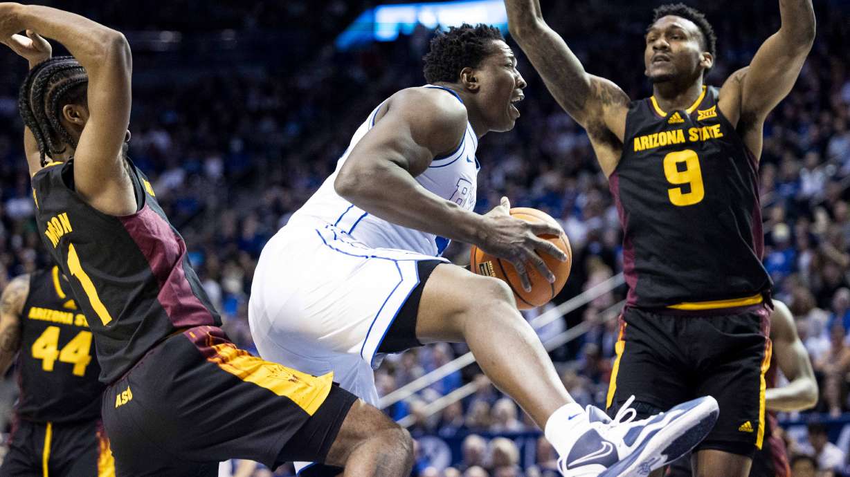 BYU center Fousseyni Traore (45) pulls down an offensive rebound while guarded by Arizona State center Shawn Phillips Jr. (9) and guard Alston Mason (1) during an NCAA men’s basketball game held at the Marriott Center in Provo on Tuesday, Dec. 31, 2024.
