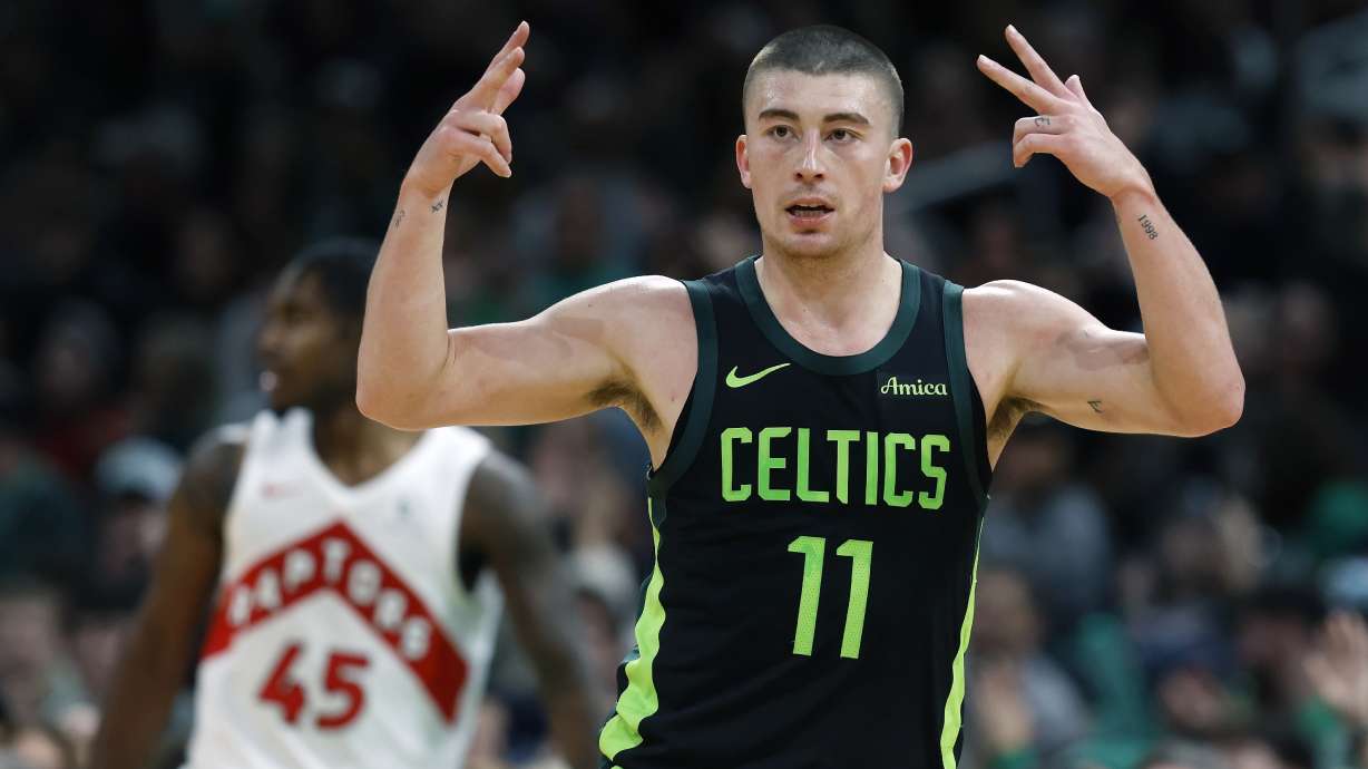 Boston Celtics' Payton Pritchard (11) celebrates his three-pointer in front of Toronto Raptors' Davion Mitchell (45) during the first half of an NBA basketball game, Tuesday, Dec. 31, 2024, in Boston.