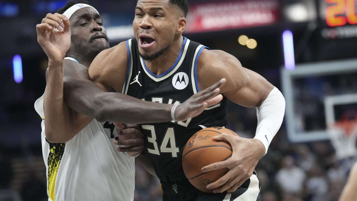 Milwaukee Bucks forward Giannis Antetokounmpo, right, goes around Indiana Pacers forward Pascal Siakam (43) during the first half of an NBA basketball game in Indianapolis, Tuesday, Dec. 31, 2024.