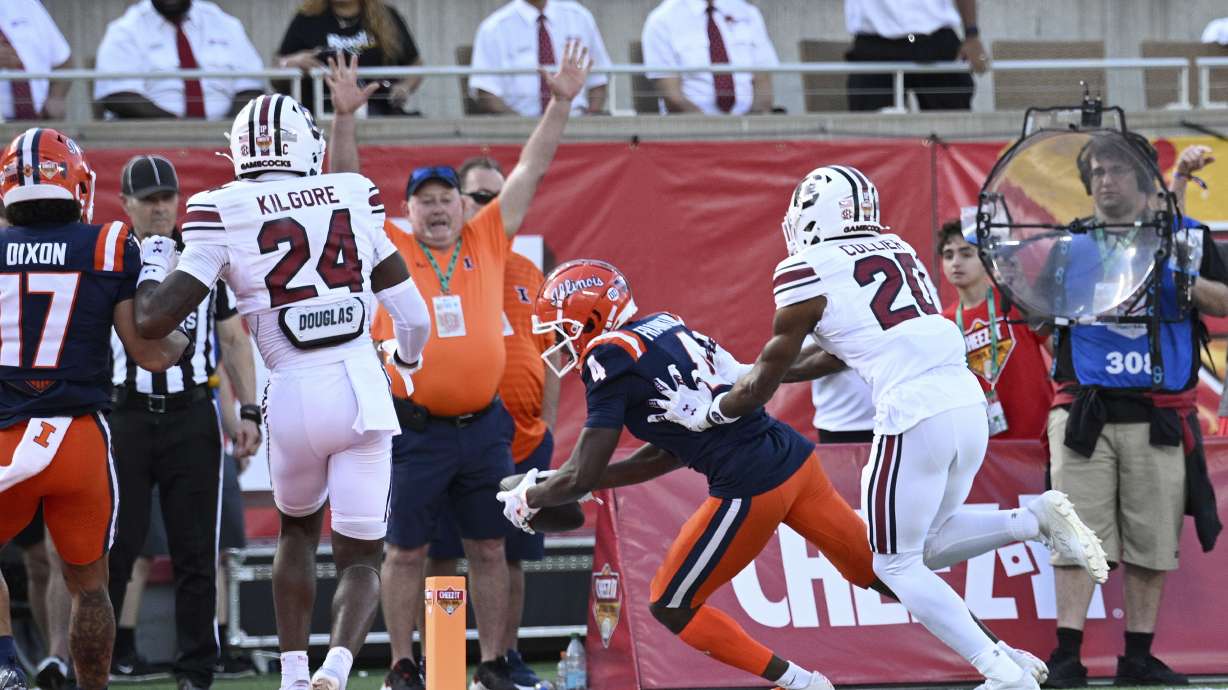 Illinois wide receiver Zakhari Franklin (4) scores a touchdown pass play in front of South Carolina defensive backs Judge Collier (20) and Jalon Kilgore (24) during the first half of the Citrus Bowl NCAA college football game, Tuesday, Dec. 31, 2024, in Orlando, Fla.