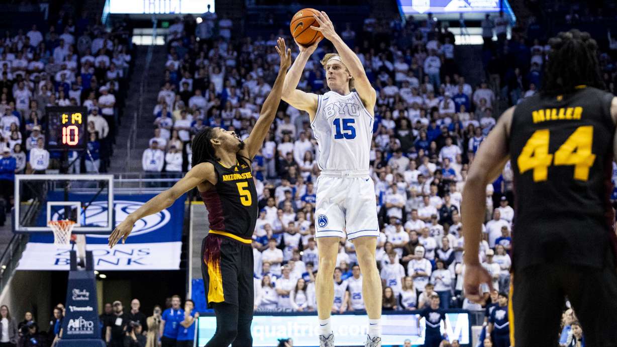 BYU guard Richie Saunders (15) takes and makes a three-pointer while guarded by Arizona State guard Amier Ali (5) for Saunders’ 30th points during an NCAA men’s basketball game held at the Marriott Center in Provo on Tuesday, Dec. 31, 2024.