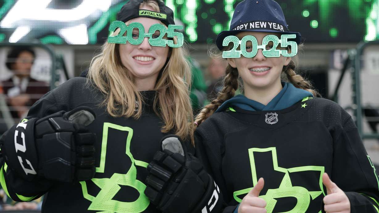Lauren Spurgin, left, and Kate Spurgin, of Dallas, wear festive New Year's glasses prior to an NHL hockey game between the Buffalo Sabres and the Dallas Stars in Dallas, Tuesday, Dec. 31, 2024.