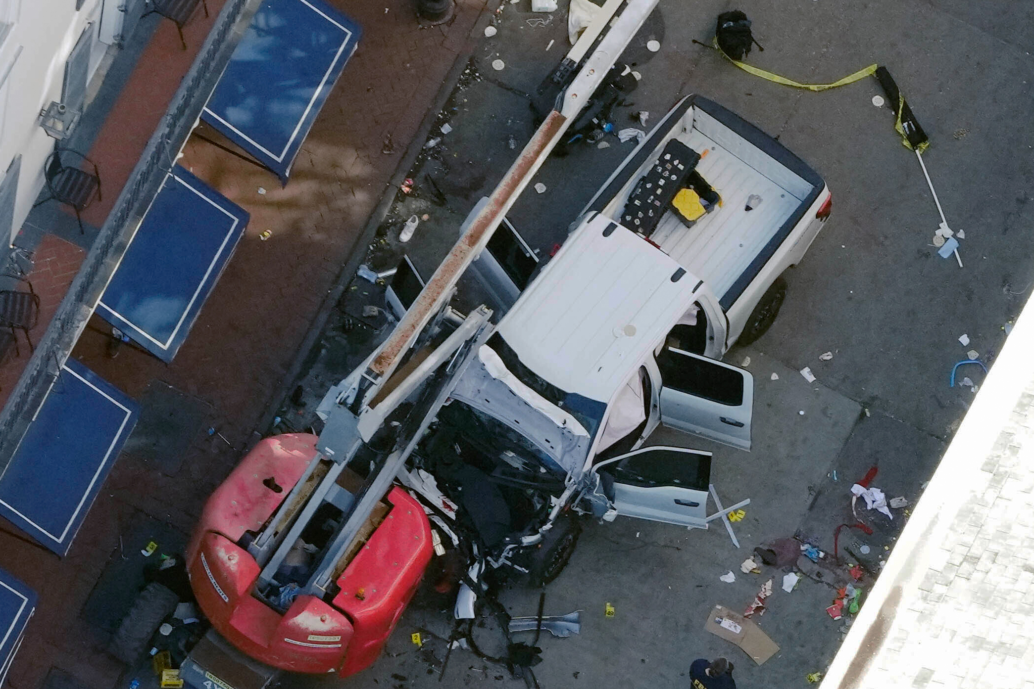 A black flag with white lettering lies on the ground rolled up behind a pickup truck that a man drove into a crowd on Bourbon Street in New Orleans, killing and injuring a number of people, early Wednesday morning. The FBI said they recovered an Islamic State group flag, which is black with white lettering, from the vehicle.