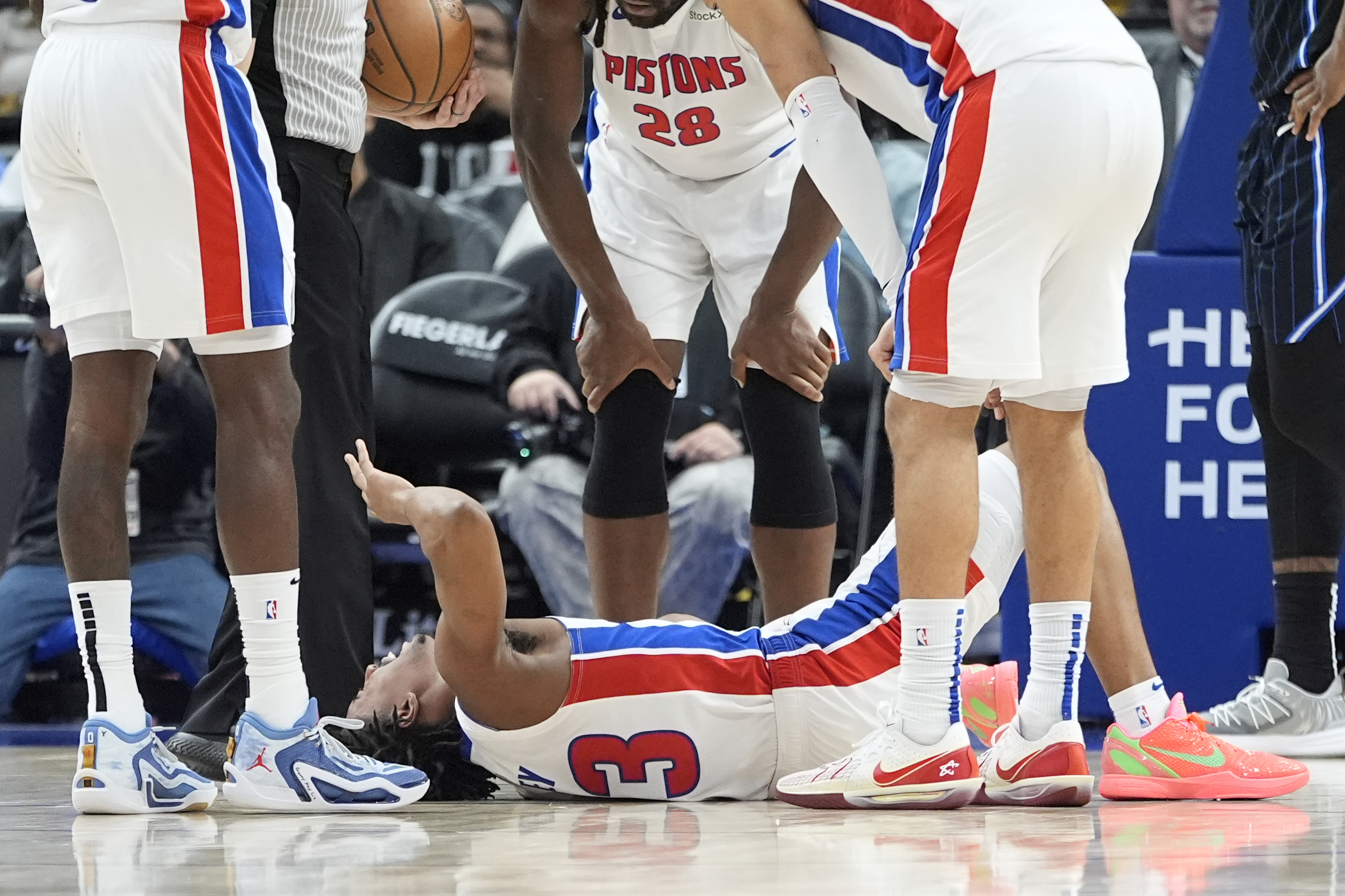 Teammates look over Detroit Pistons guard Jaden Ivey (23) after an incident during the second half of an NBA basketball game against the Orlando Magic, Wednesday, Jan. 1, 2025, in Detroit.
