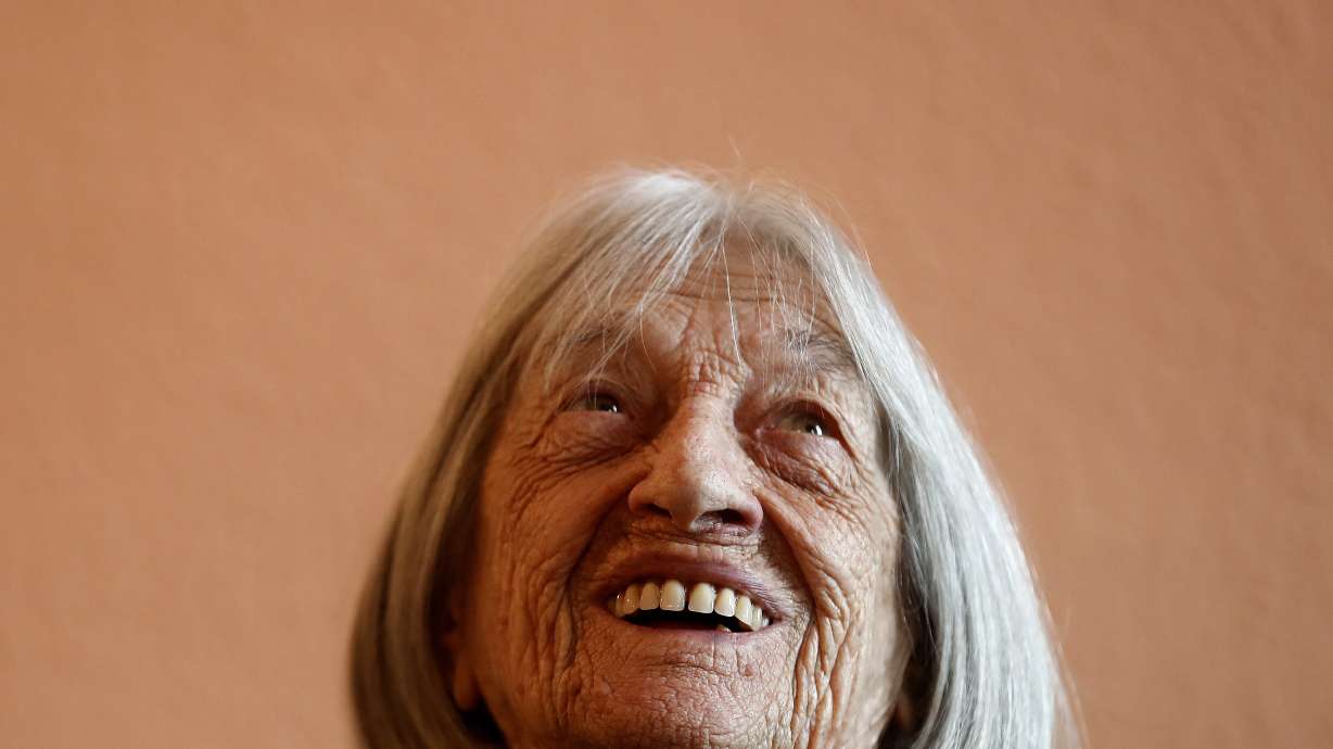 FILE - Agnes Keleti, former Olympic gold medal winning gymnast, smiles at her apartment in Budapest, Hungary Wednesday Jan. 8, 2020.