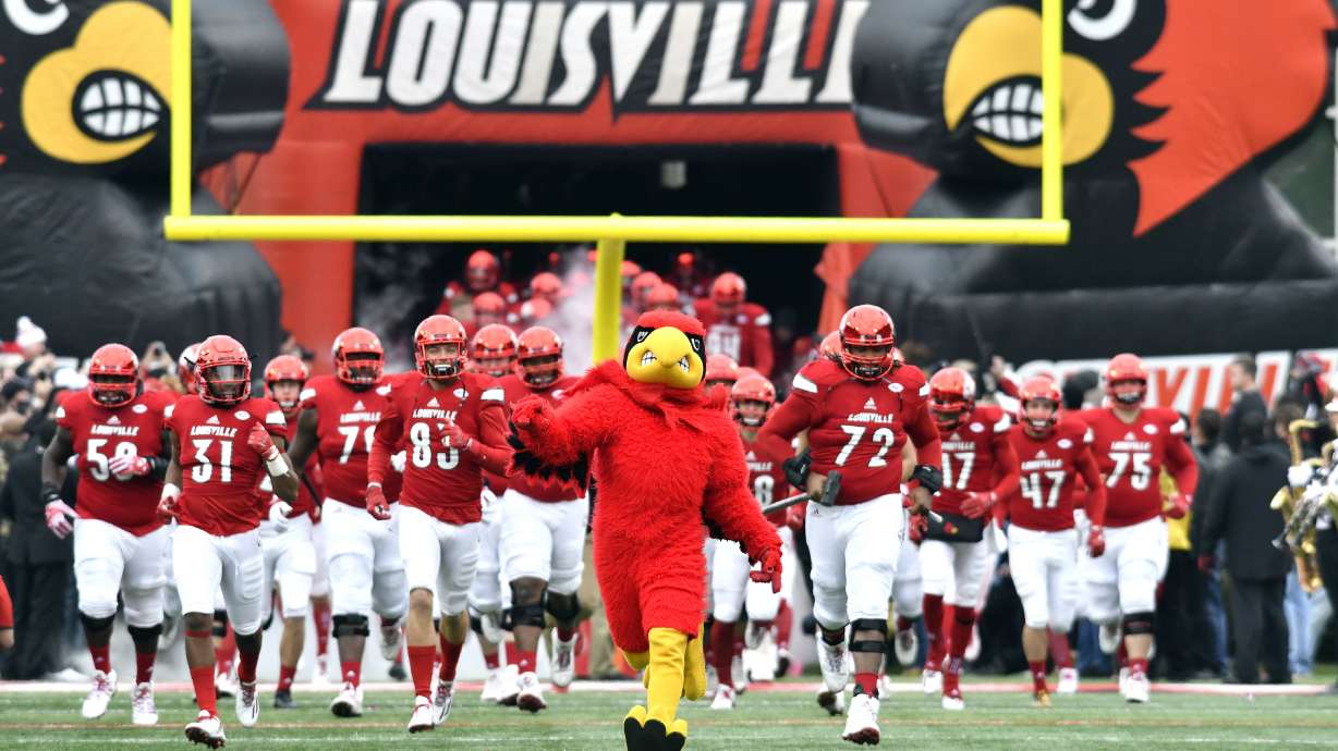 FILE - Louisville players run onto the field before an NCAA college football game against Kentucky, Saturday, Nov. 26, 2016, in Louisville, Ky.