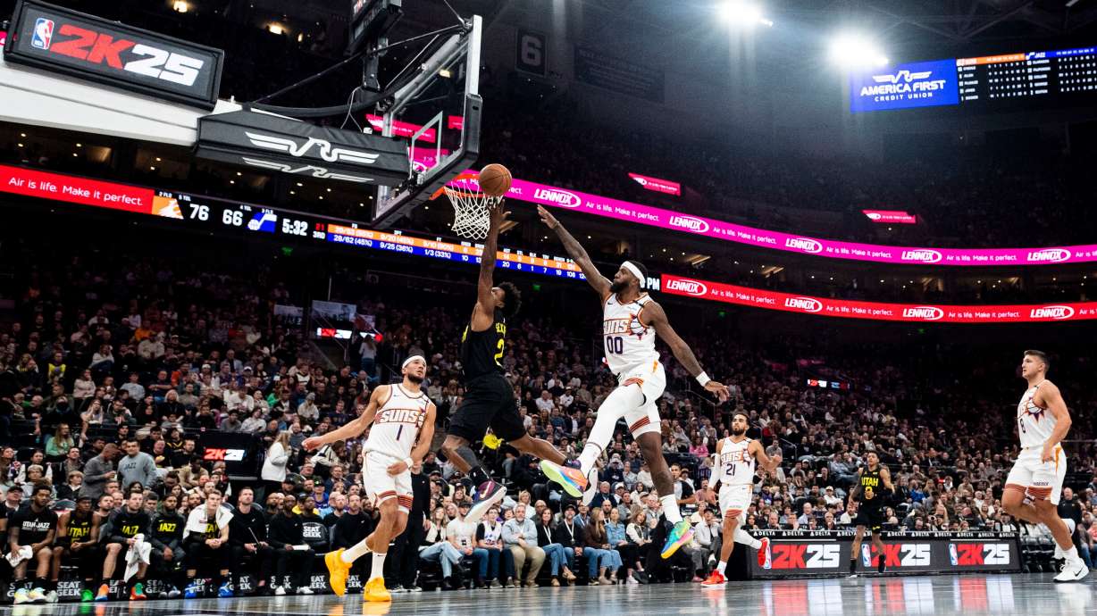 Utah Jazz guard Collin Sexton (2) lays the ball up while guarded by Phoenix Suns forward Royce O'Neale (00) during an NBA basketball game held at the Delta Center in Salt Lake City on Nov. 12.