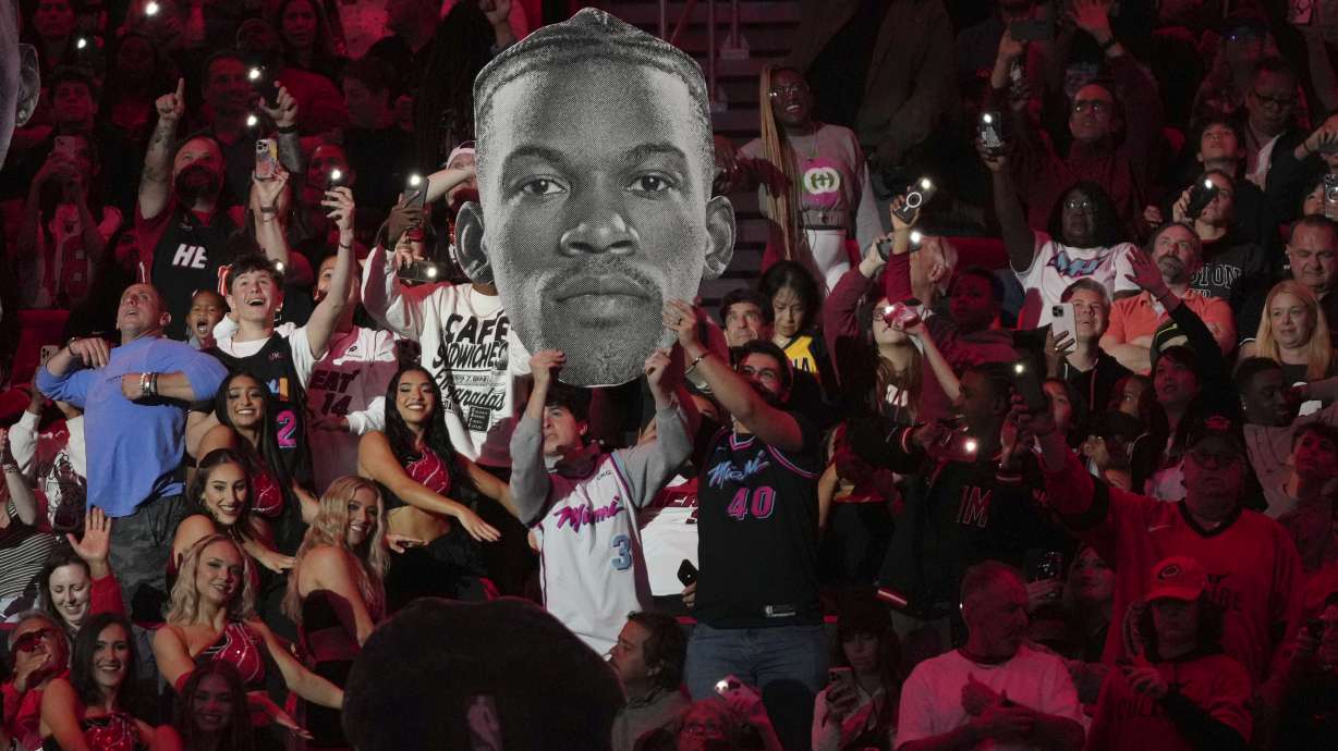 Fans hold up a portrait of Miami Heat forward Jimmy Butler during the second half of an NBA basketball game against the Indiana Pacers Thursday, Jan. 2, 2025, in Miami.