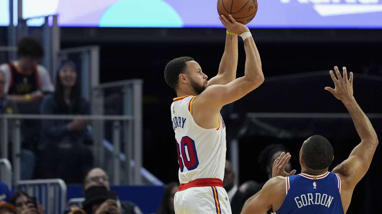 Golden State Warriors guard Stephen Curry, left, shoots a 3-point basket next to Philadelphia 76ers guard Eric Gordon during the first half of an NBA basketball game, Thursday, Jan. 2, 2025, in San Francisco.