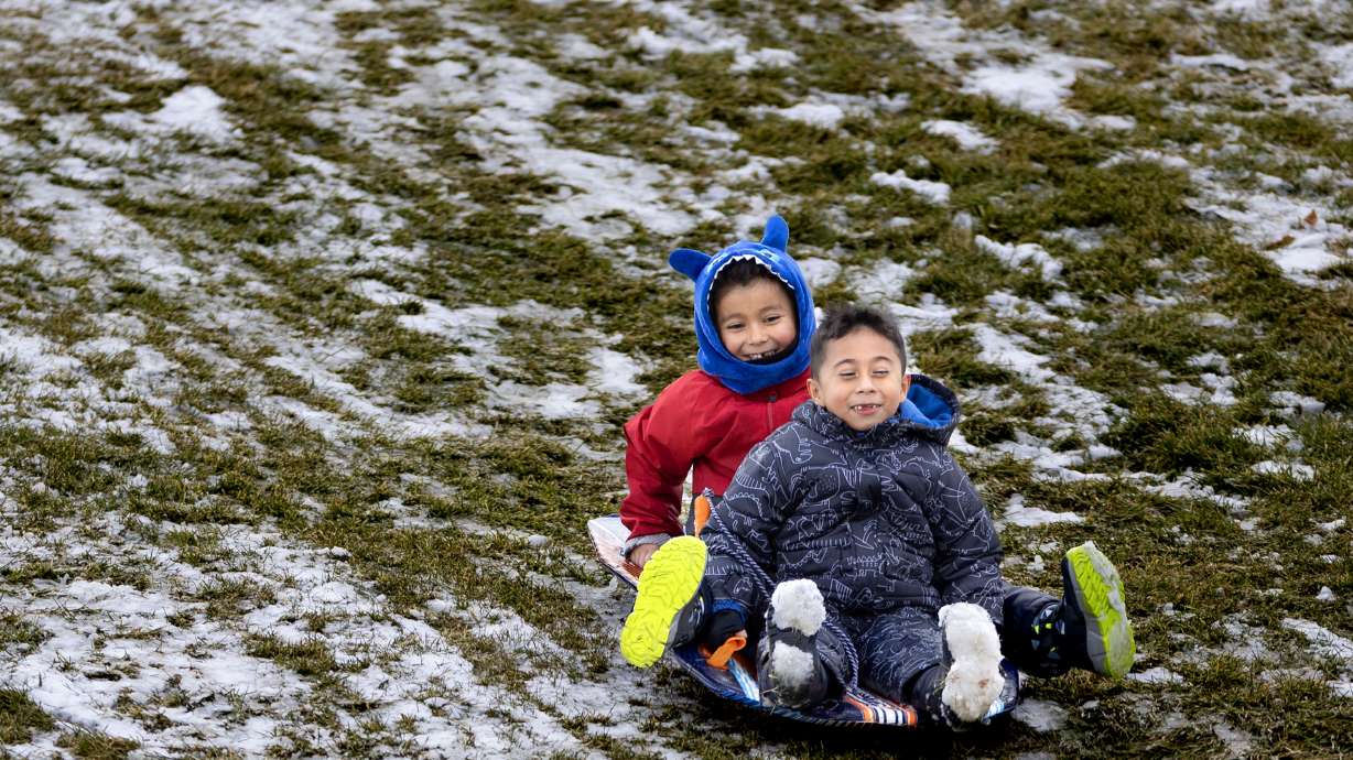 Alejandro Patiño and Joshua Cifuentes sled at Sugar House Park in Salt Lake City on Dec. 26, 2024. Salt Lake City remains on pace for its sixth-lowest snowfall year as of Wednesday, receiving less now than some cities in the Southeast.
