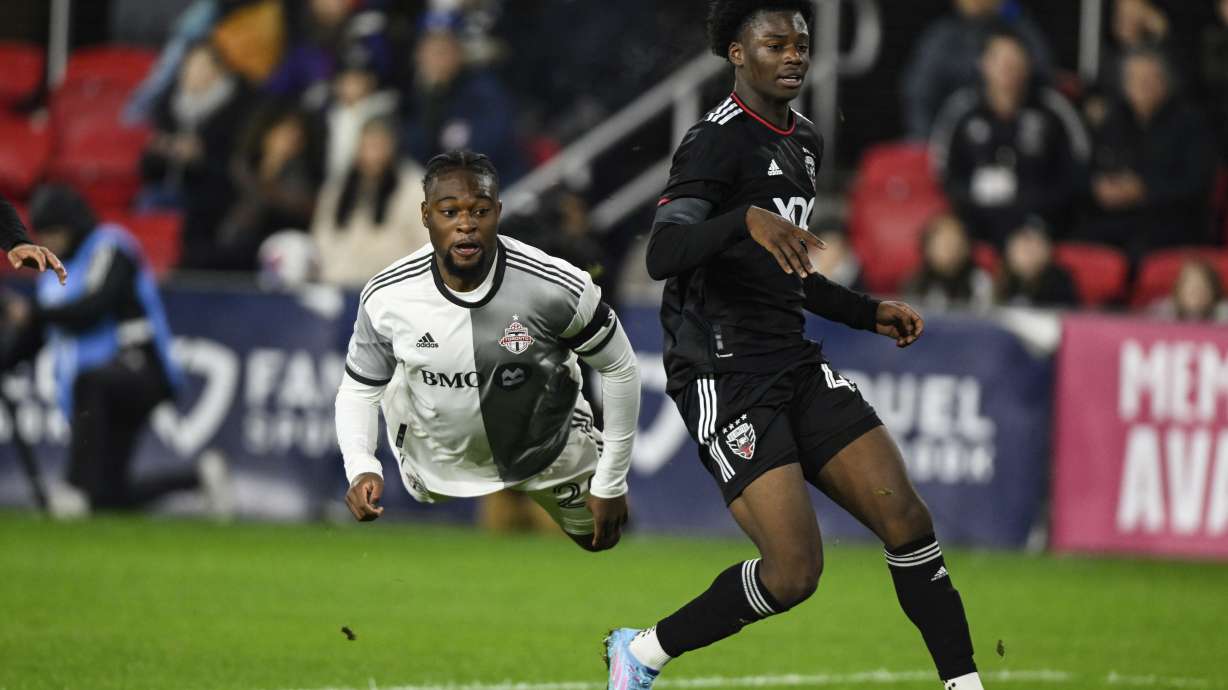 Toronto FC forward Ayo Akinola goes airborne after attempting a shot on goal against D.C. United defender Matai Akinmboni during the first half of an MLS soccer match, Saturday, Feb. 25, 2023, in Washington.