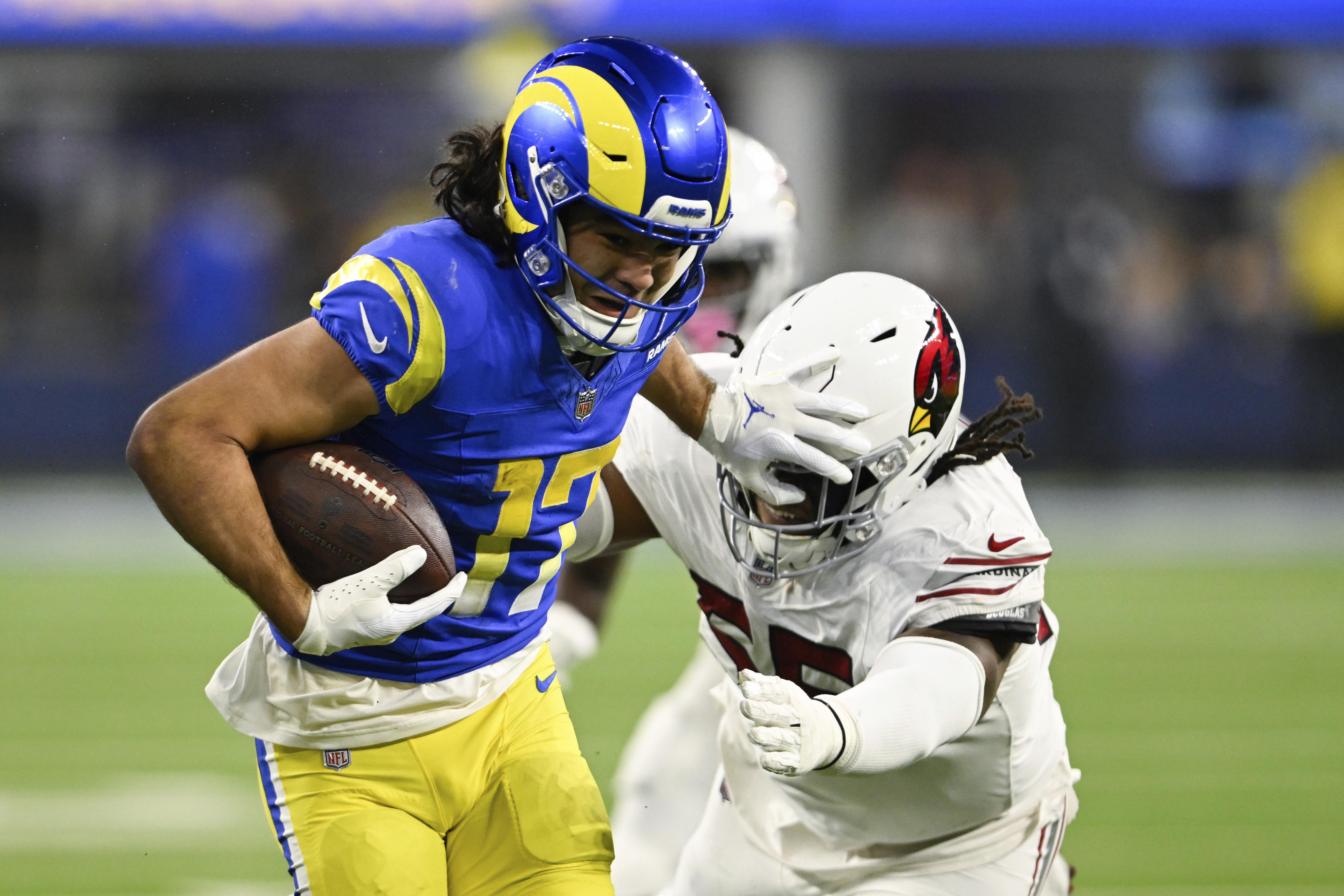 Los Angeles Rams wide receiver Puka Nacua (17) stiff-arms Arizona Cardinals defensive tackle Dante Stills (55) after a reception during the second half of an NFL football game Saturday, Dec. 28, 2024, in Inglewood, Calif. 