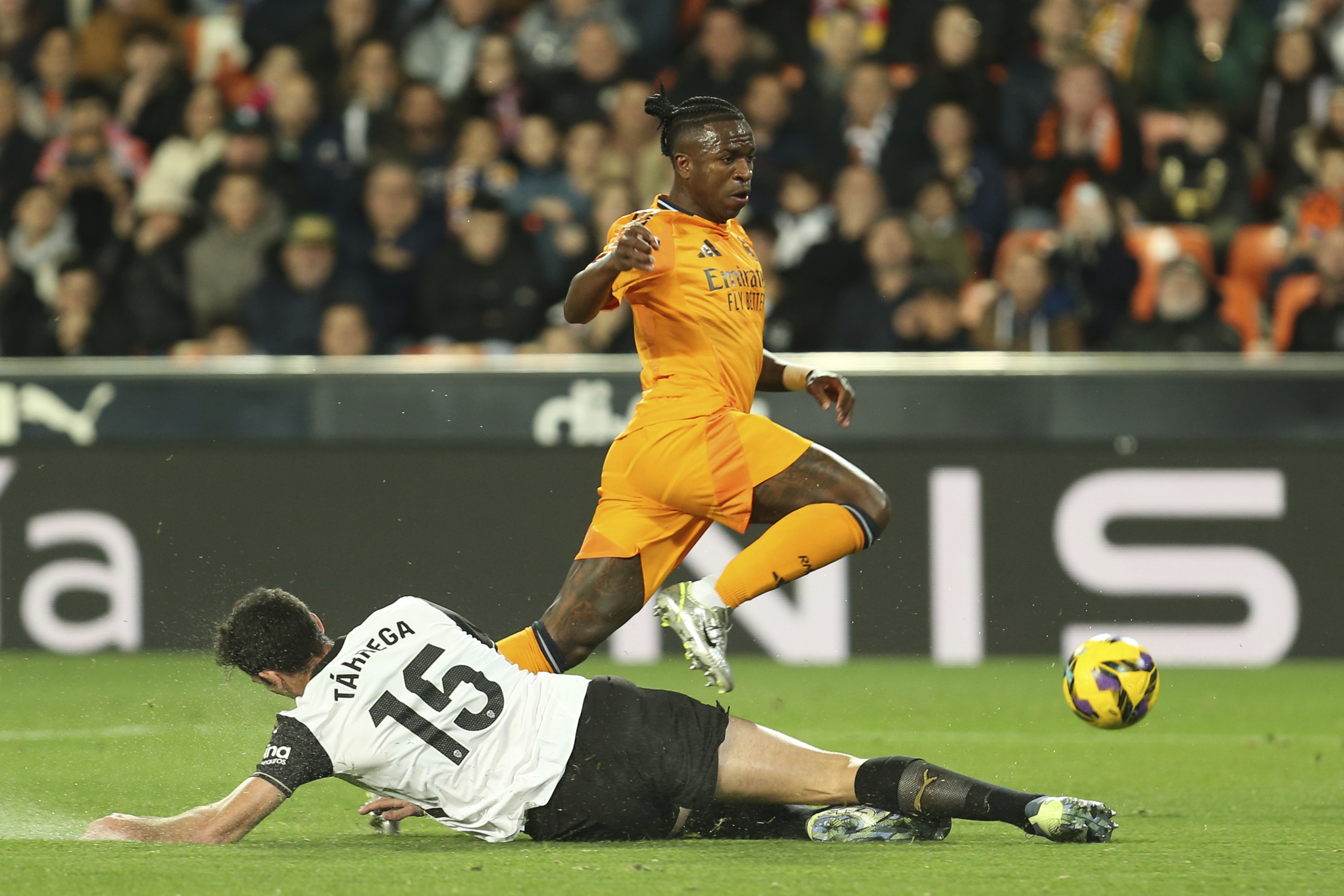 Real Madrid's Vinicius Junior, top, and Valencia's Cesar Tarrega fight for the ball during a Spanish La Liga soccer match at Mestalla stadium in Valencia, Spain, Friday, Jan. 3, 2025.