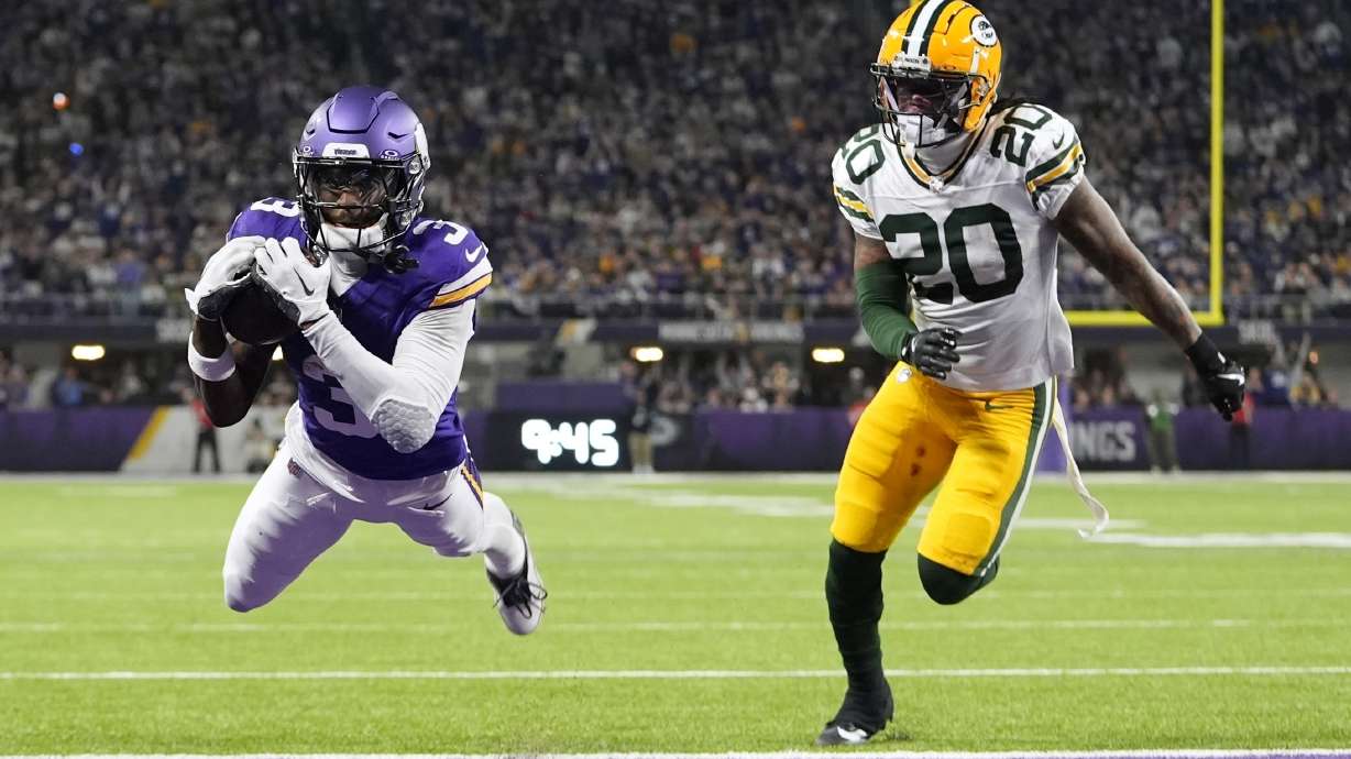 Minnesota Vikings' Jordan Addison catches a touchdown pass in front of Green Bay Packers' Javon Bullard during the second half of an NFL football game Sunday, Dec. 29, 2024, in Minneapolis.