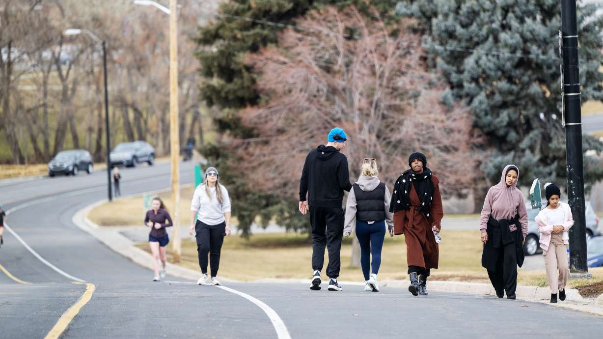 People walk at Sugarhouse Park as warmer weather moves into the Salt Lake Valley on Friday.