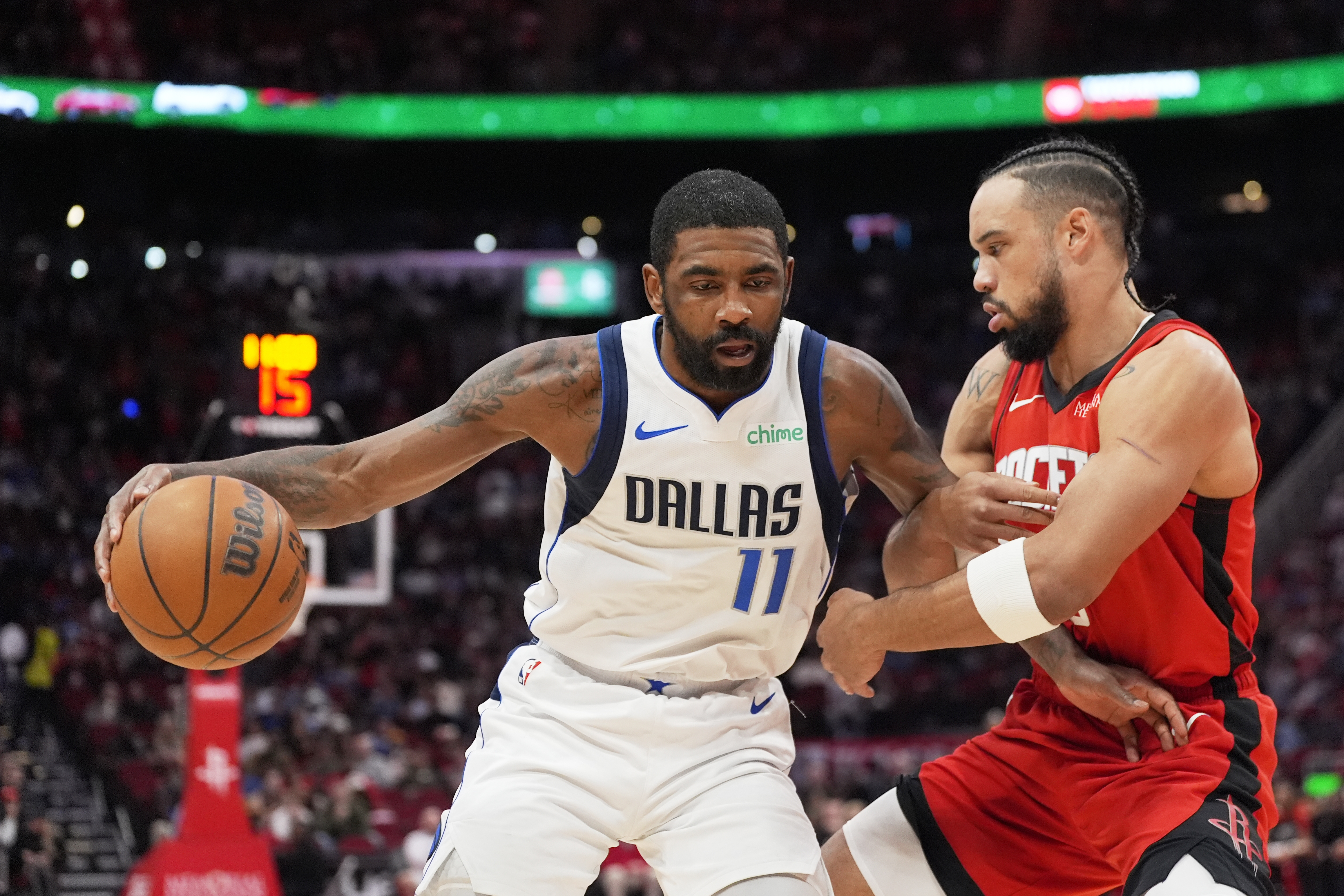 Dallas Mavericks' Kyrie Irving (11) is defended by Houston Rockets' Dillon Brooks during the first half of an NBA basketball game Wednesday, Jan. 1, 2025, in Houston.