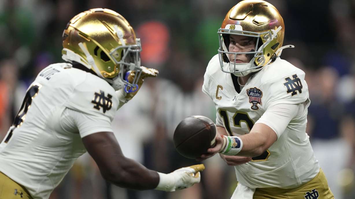 Notre Dame quarterback Riley Leonard hands the ball off to running back Jeremiyah Love, left, during the first half against Georgia in the quarterfinals of a College Football Playoff, Thursday, Jan. 2, 2025, in New Orleans.