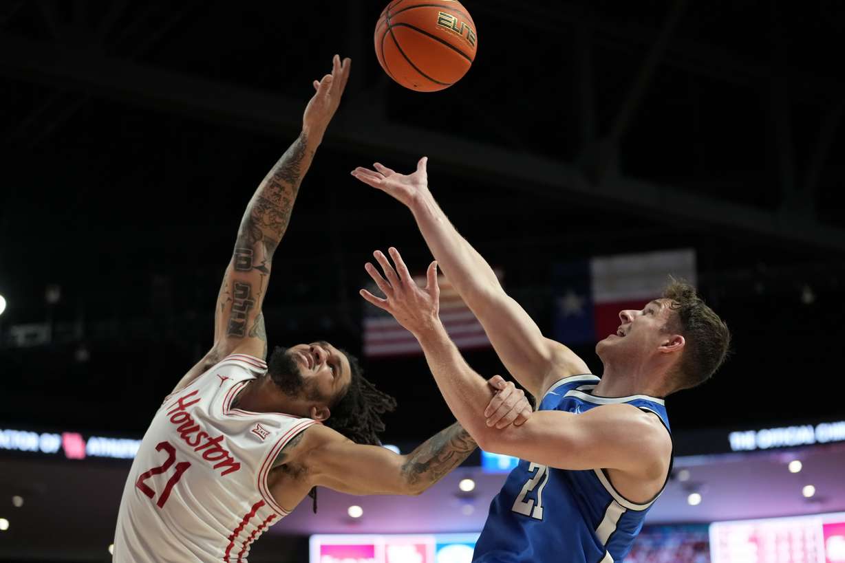 Houston guard Emanuel Sharp, left, and Brigham Young guard Trevin Knell reach for a rebound during the first half of an NCAA college basketball game in Houston, Saturday, Jan. 4, 2025.