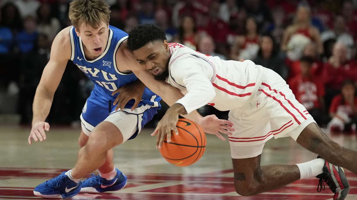 BYU guard Dallin Hall, left, and Houston guard Mylik Wilson dive for a loose ball during the second half of an NCAA college basketball game in Houston, Saturday, Jan. 4, 2025.