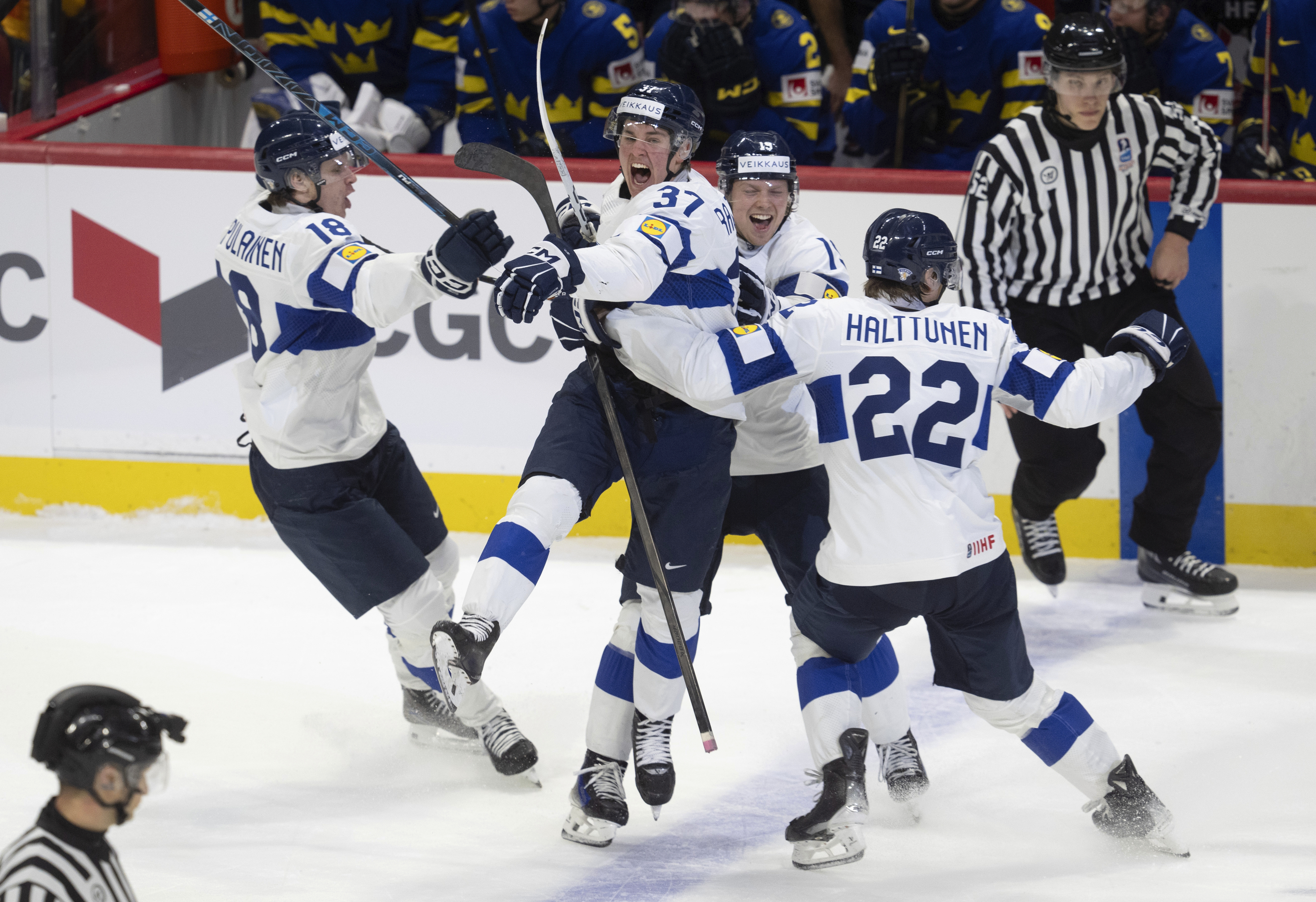 Finland's Benjamin Rautiainen (37) celebrates with teammates Rasmus Kumpulainen (18), Kasper Halttunen (22) and Konsta Helenius after scoring the game winning goal in overtime against Sweden in a semifinal game at the world junior hockey championship, Saturday, Jan. 4, 2025 in Ottawa, Ontario.