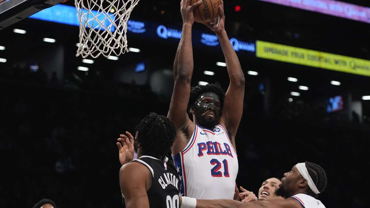Philadelphia 76ers' Joel Embiid fights for control of the ball with Brooklyn Nets' Nic Claxton (33) during the first half of an NBA basketball game Saturday, Jan. 4, 2025, in New York.