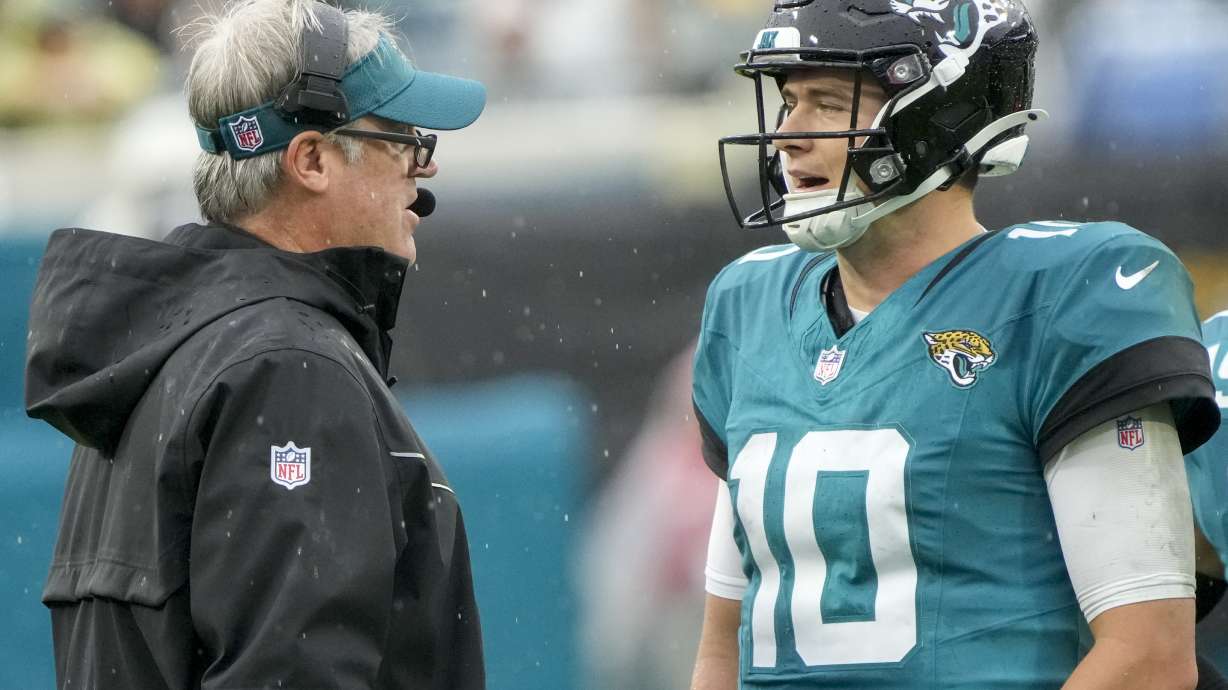 Jacksonville Jaguars head coach Doug Pederson, left, talks to quarterback Mac Jones (10) during the first half of an NFL football game against the Tennessee Titans, Sunday, Dec. 29, 2024, in Jacksonville, Fla.