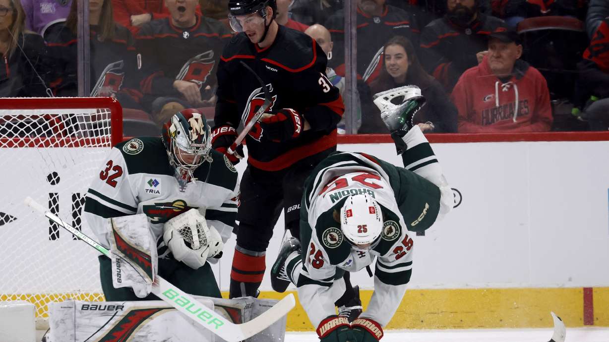 Carolina Hurricanes' Andrei Svechnikov (37) chases the puck between Minnesota Wild's Jonas Brodin (25) and goaltender Filip Gustavsson (32) during the first period of an NHL hockey game in Raleigh, N.C., Saturday, Jan. 4, 2025.