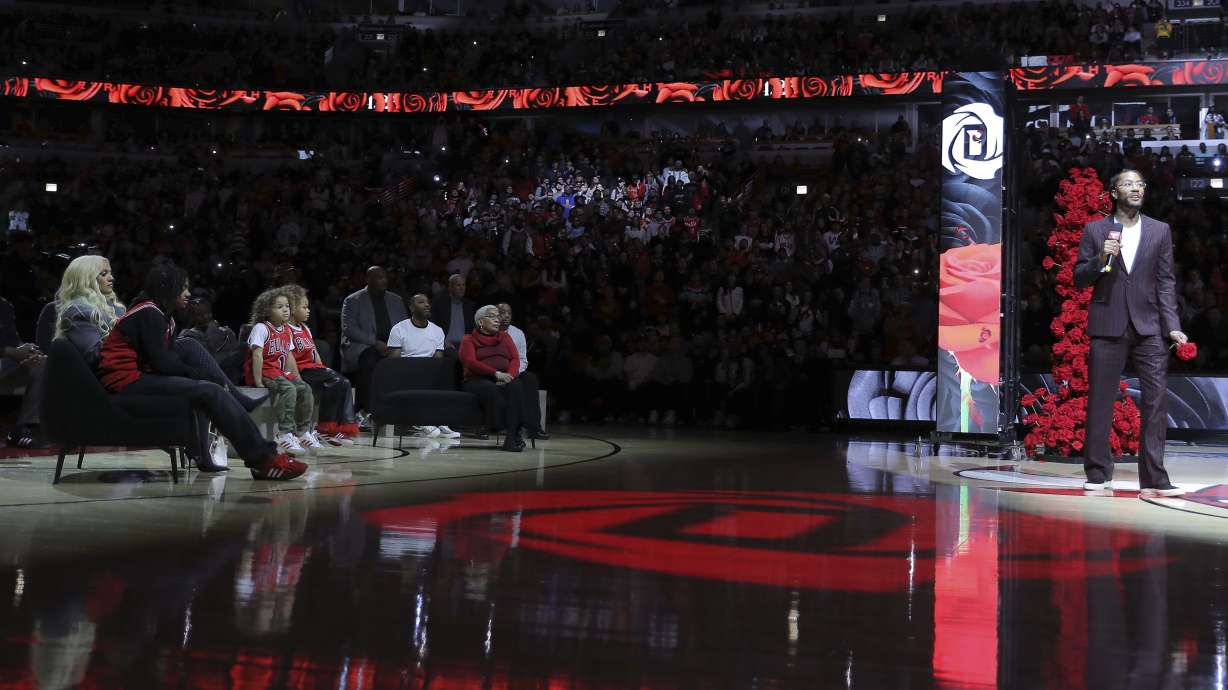Former NBA player Derrick Rose, right, speaks as his family, left, watches during a half-time ceremony during an NBA basketball game between the New York Knicks and the Chicago Bulls, Saturday, Jan. 4, 2025, in Chicago.