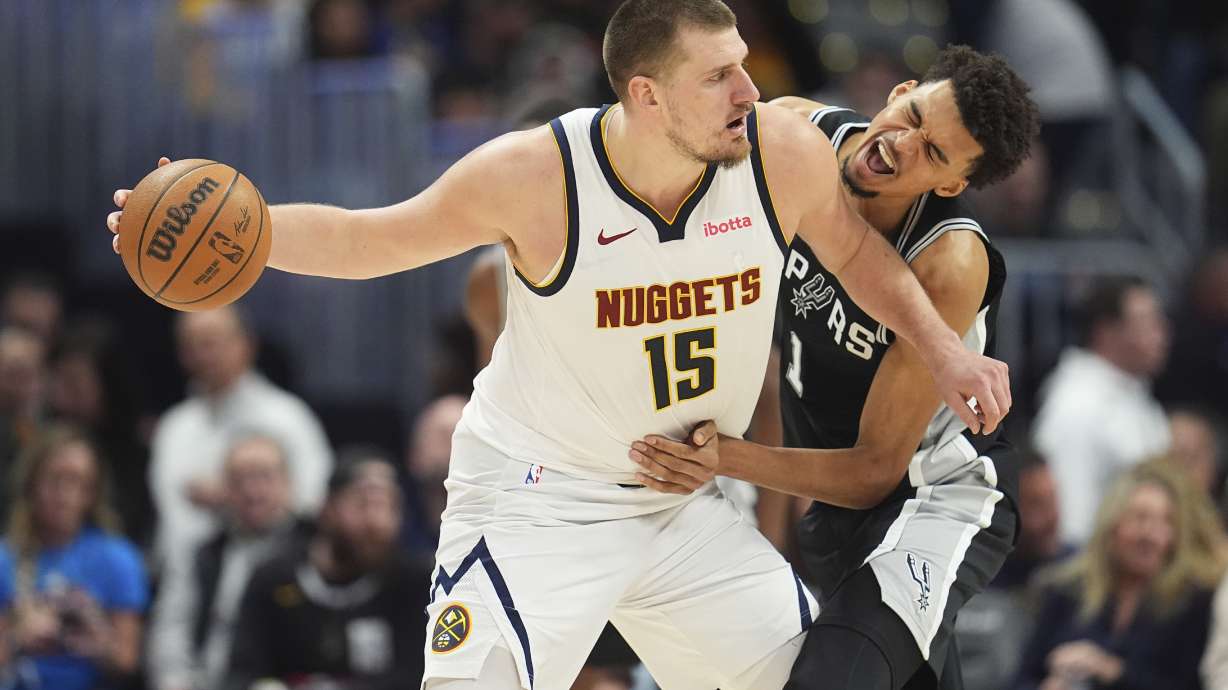 Denver Nuggets center Nikola Jokic, looks to pass the ball as San Antonio Spurs center Victor Wembanyama defends in the second half of an NBA basketball game Friday, Jan. 3, 2025, in Denver.