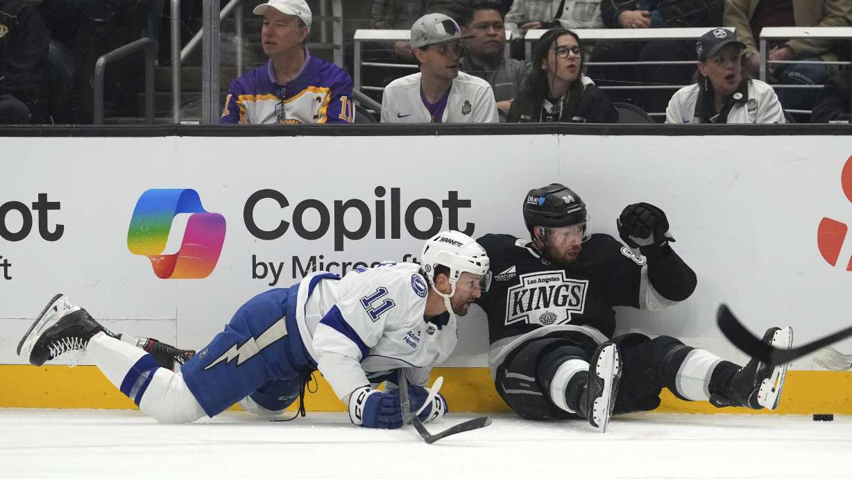 Tampa Bay Lightning center Luke Glendening, left, and Los Angeles Kings defenseman Vladislav Gavrikov fall as they vie for the puck during the first period of an NHL hockey game, Saturday, Jan. 4, 2025, in Los Angeles.
