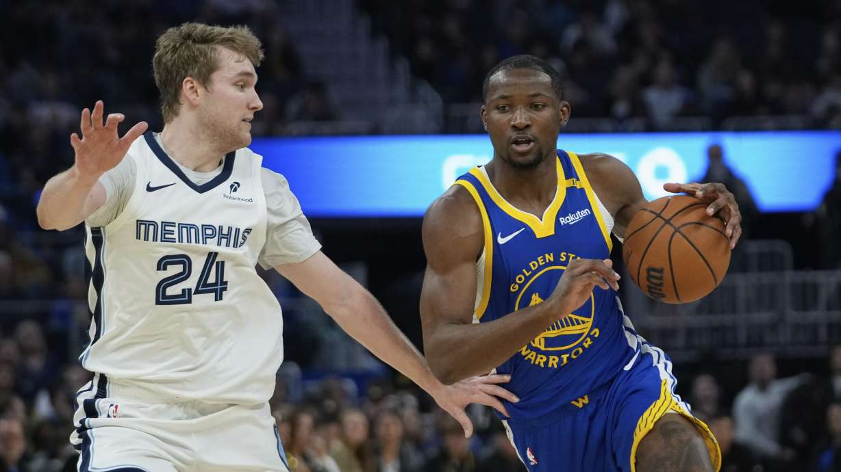 Golden State Warriors forward Jonathan Kuminga, right, moves the ball while defended by Memphis Grizzlies guard Cam Spencer during the first half of an NBA basketball game Saturday, Jan. 4, 2025, in San Francisco.