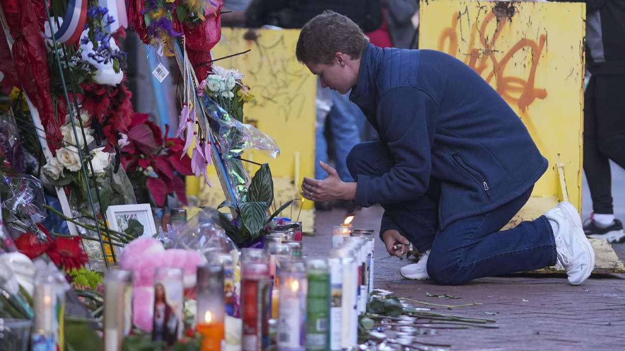 Nathan Williams, a University of New Orleans student, lights a candle at memorial on Bourbon Street for the victims of a deadly truck attack on New Year's Day in New Orleans, Friday.