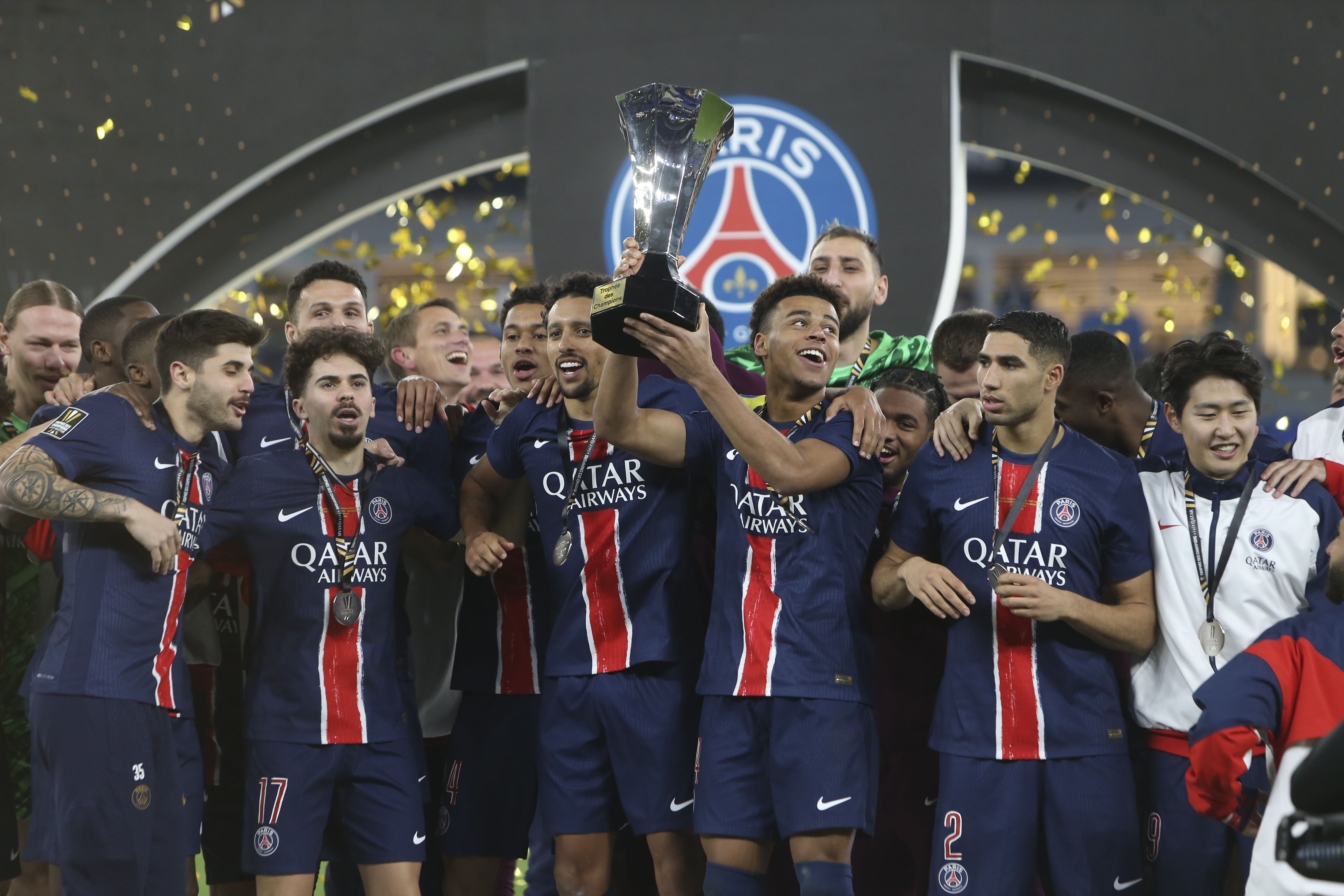 PSG players celebrate with a trophy after the French Super Cup final match between Paris Saint Germain and Monaco in Doha, Qatar, on Sunday, Jan. 5, 2025.