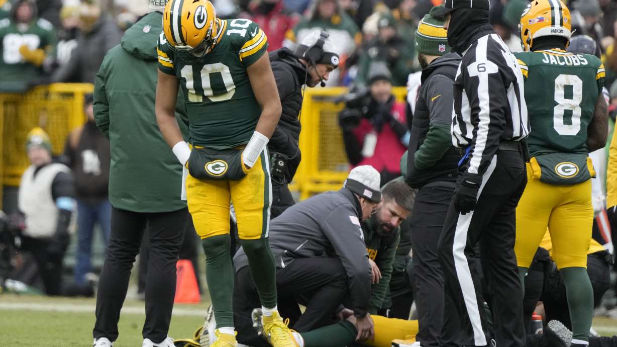 Green Bay Packers quarterback Jordan Love (10) reacts as wide receiver Christian Watson, bottom, is checked on during the first half of an NFL football game against the Chicago Bears, Sunday, Jan. 5, 2025, in Green Bay, Wis.