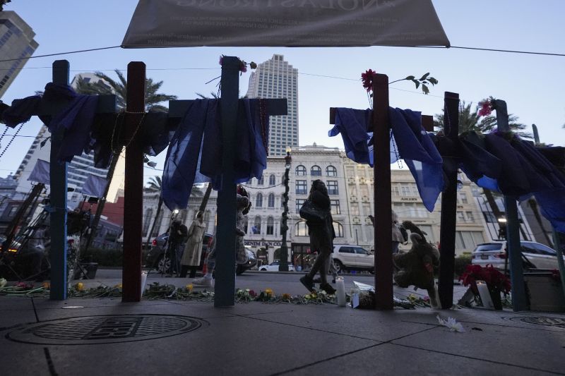 People walk past a memorial on Canal Street for the victims of a deadly truck attack on New Year's Day in New Orleans, Friday.