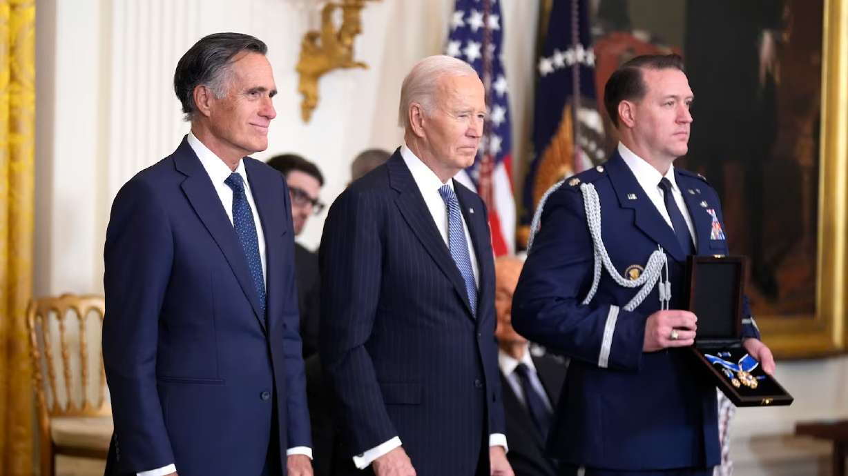 President Joe Biden prepares to posthumously present the Presidential Medal of Freedom to former Sen. Mitt Romney on behalf of his late father, George Romney, in the East Room of the White House, on Saturday, in Washington.