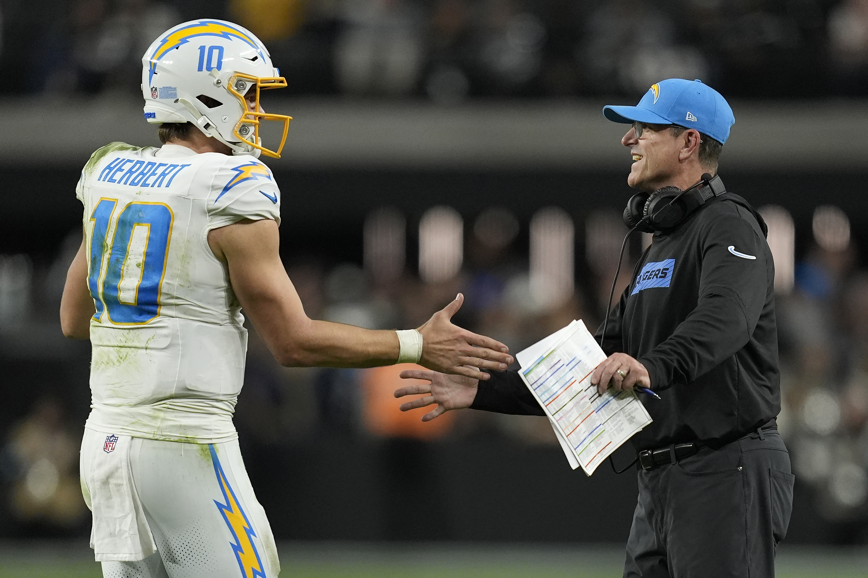 Los Angeles Chargers quarterback Justin Herbert (10) celebrates with head coach Jim Harbaugh during the second half of an NFL football game against the Las Vegas Raiders in Las Vegas, Sunday, Jan. 5, 2025. 